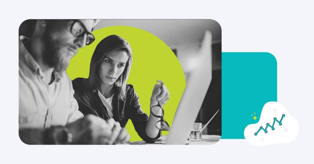 A woman collaborates with a male coworker on a laptop improving a lead nurture campaign.