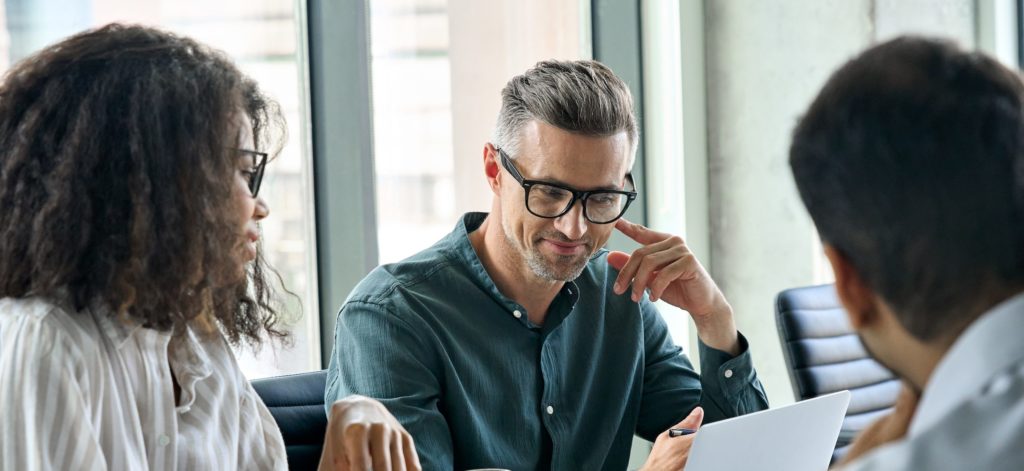 A man and woman reviewing the best financial services advertising campaigns on a laptop.