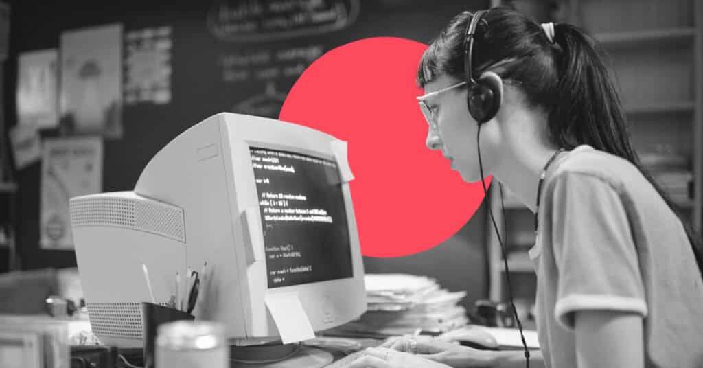 A woman operates an outdated computer wearing outdated headphones.