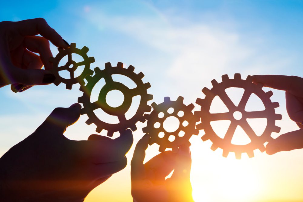 AMB strategies illustrated by hands holding gears.