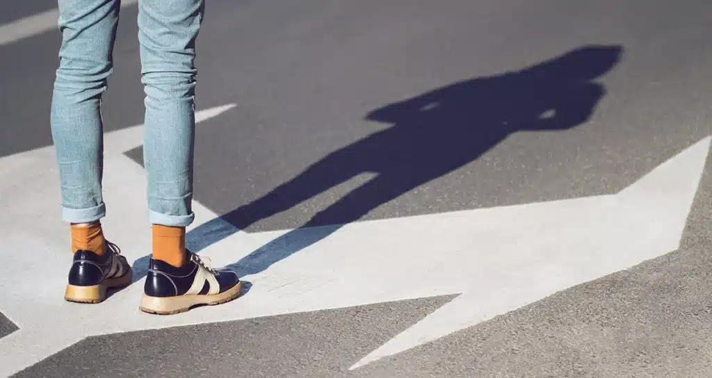 Customer Journey Mapping illustrated by a person standing on a crossroad.