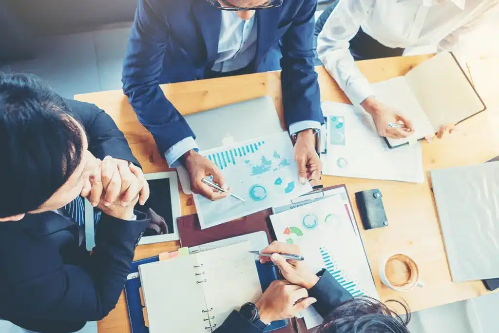 Marketers gathered at a table discussing how to improve marketing campaigns.