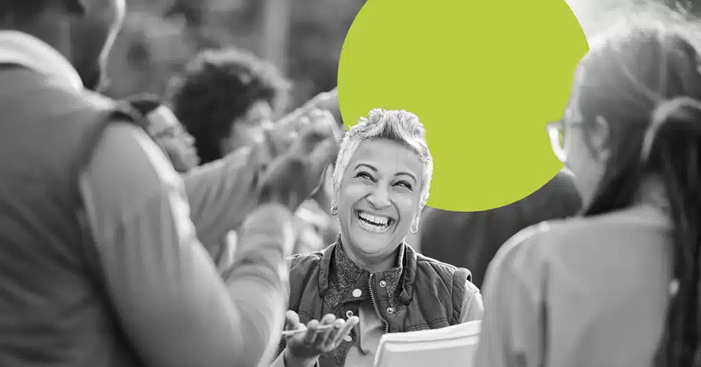 a smiling woman holds a clipboard and speaks about her brand advocacy program.